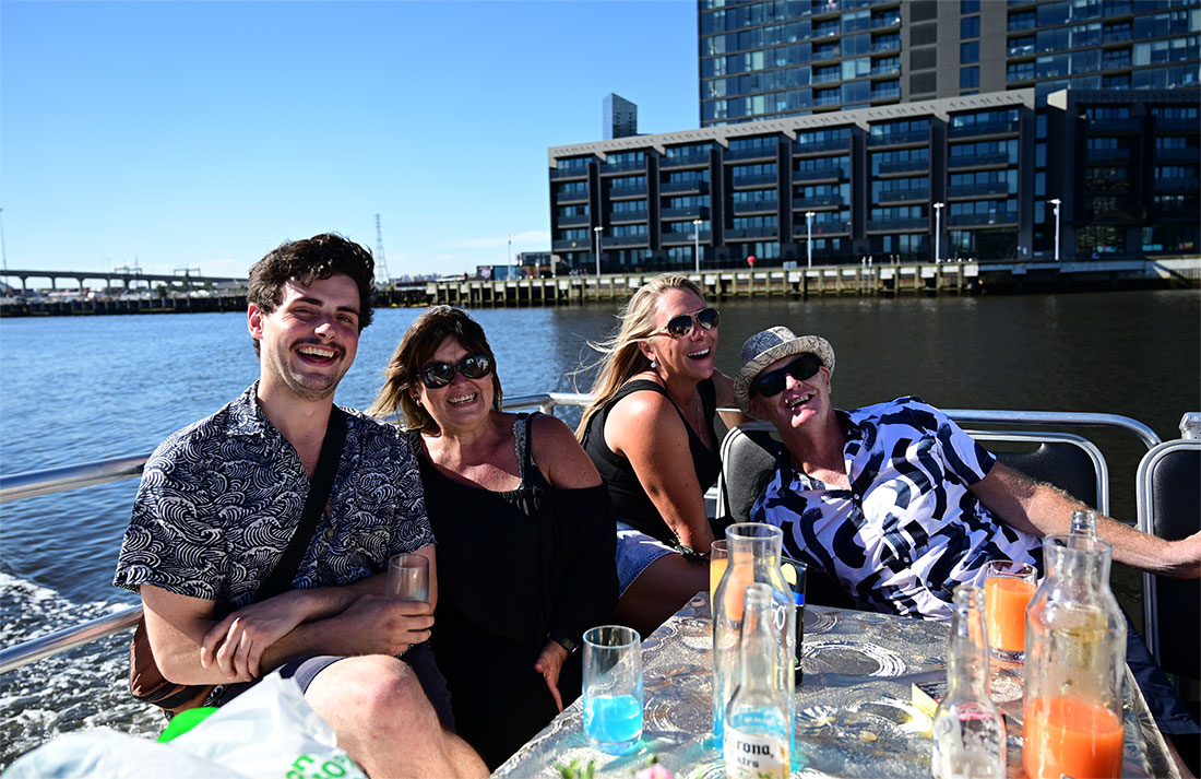 people enjoying drinks in the sun on yarra river cruise